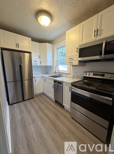 A kitchen with a refrigerator, oven, and microwave.