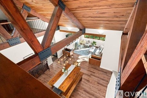 A wooden staircase leads to a living room with a couch and a coffee table.