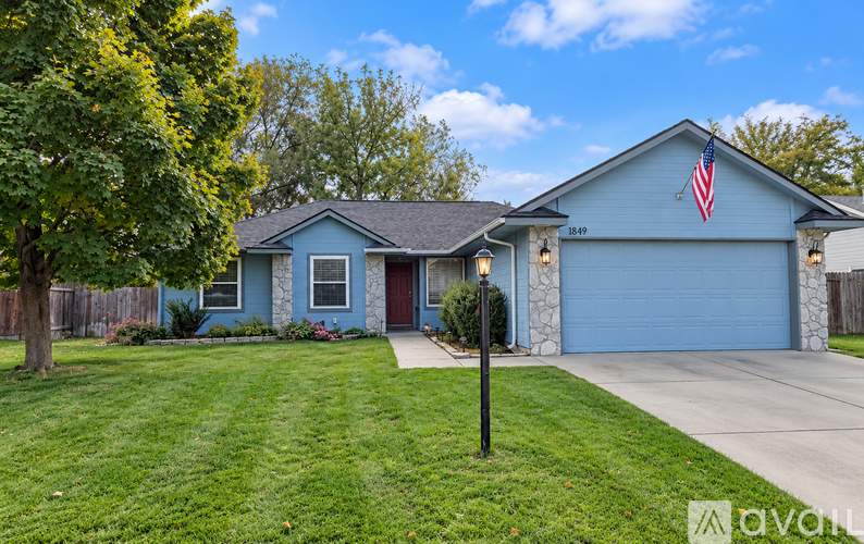 A house with a blue exterior and a flag on the garage door.