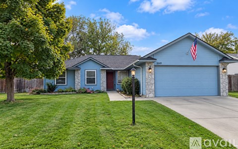 A house with a blue exterior and a flag on the garage door.