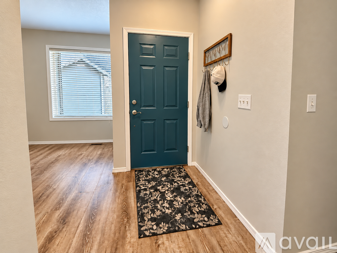 A dark teal door is set into a light-colored wall.