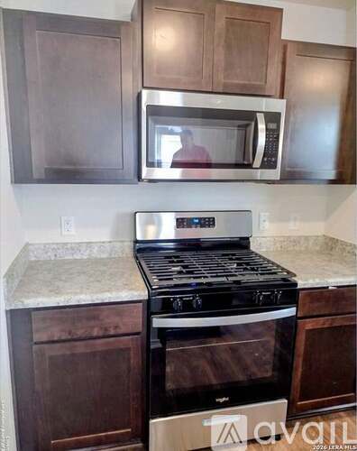 A kitchen with a stove and microwave above it.