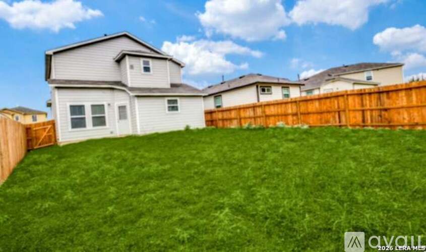 A house with a fence and a grassy yard is for sale.