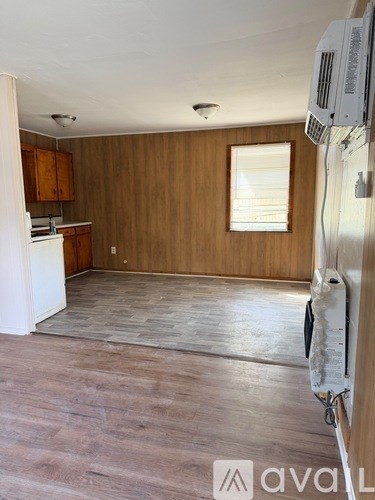 A kitchen with wooden cabinets and a window.