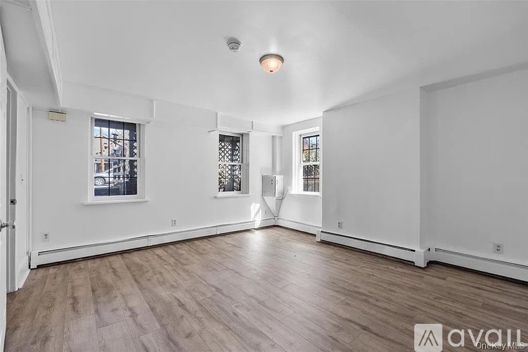 A spacious room with wooden floors and white walls.