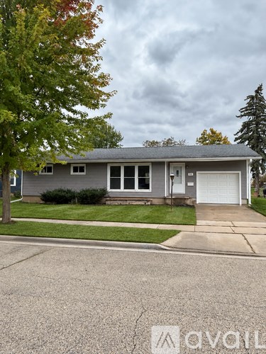 A house with a grey roof and a white garage door is shown.
