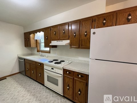A kitchen with wooden cabinets and a white refrigerator.
