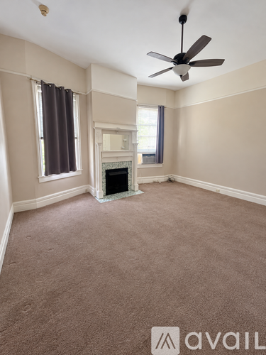 A room with a fireplace and a fan on the ceiling.