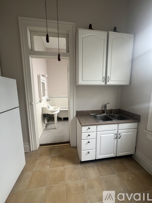 A kitchen with white cabinets and a white fridge.