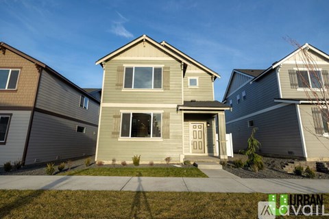 A house with a grey front yard is in the foreground of the image.
