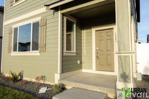 A house with a brown door and a window with a reflection of a tree.