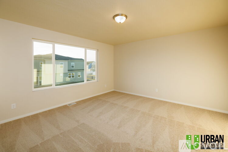 A room with a window showing a view of buildings outside.
