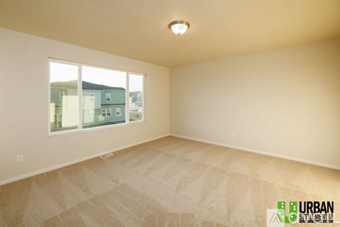 A room with a window showing a view of buildings outside.