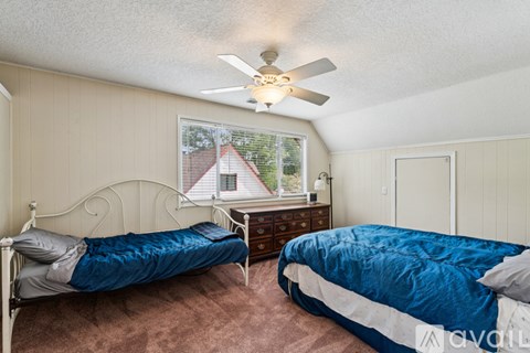 A bedroom with two beds and a dresser.