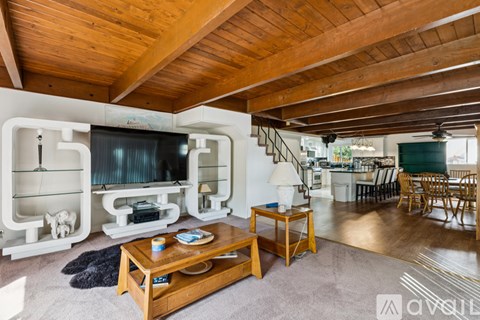 A living room with a wooden ceiling and a television.