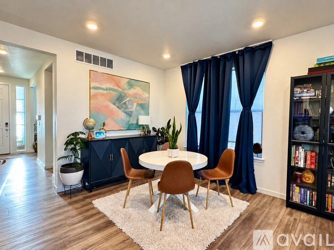 A dining room with a round table and chairs.