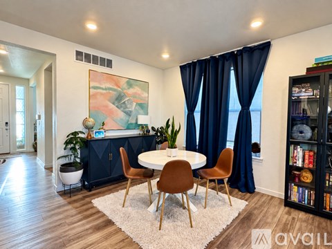 A dining room with a round table and chairs.