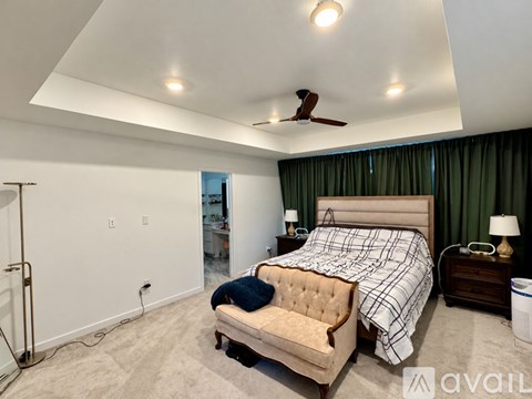 A bedroom with a large bed and a ceiling fan.