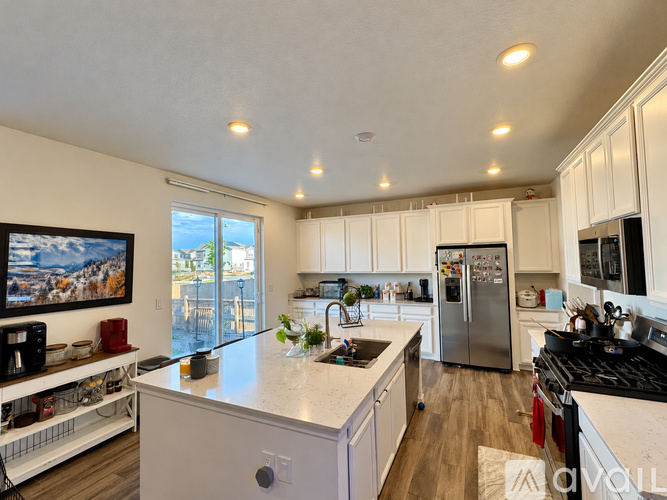 A modern kitchen with white cabinets and a large island.