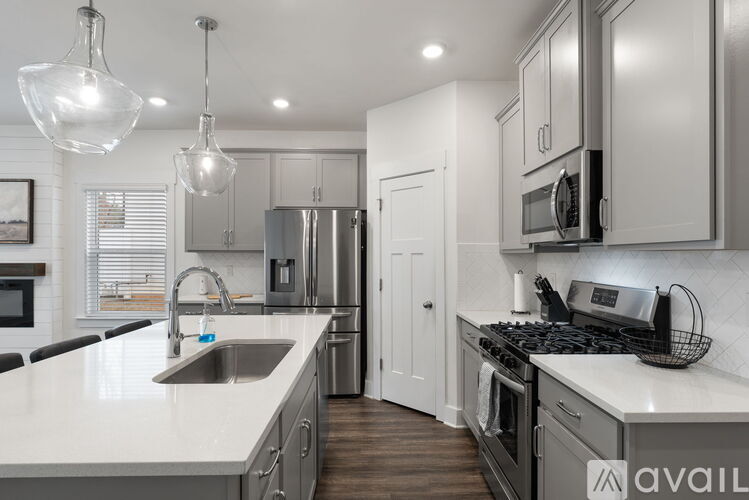 A modern kitchen with a stainless steel refrigerator and a white countertop.