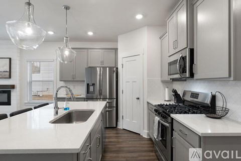 A modern kitchen with a stainless steel refrigerator and a white countertop.