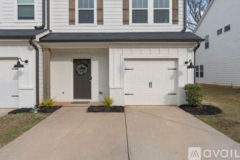 A house with a black front door and two garages.