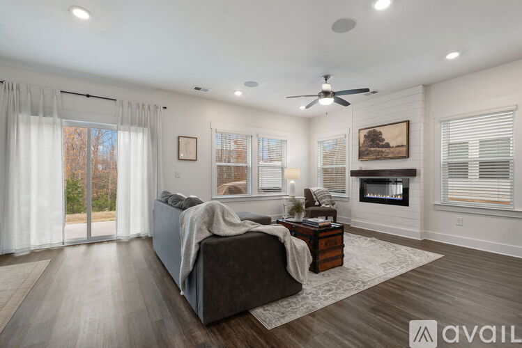A spacious living room with a grey sofa and a fireplace.