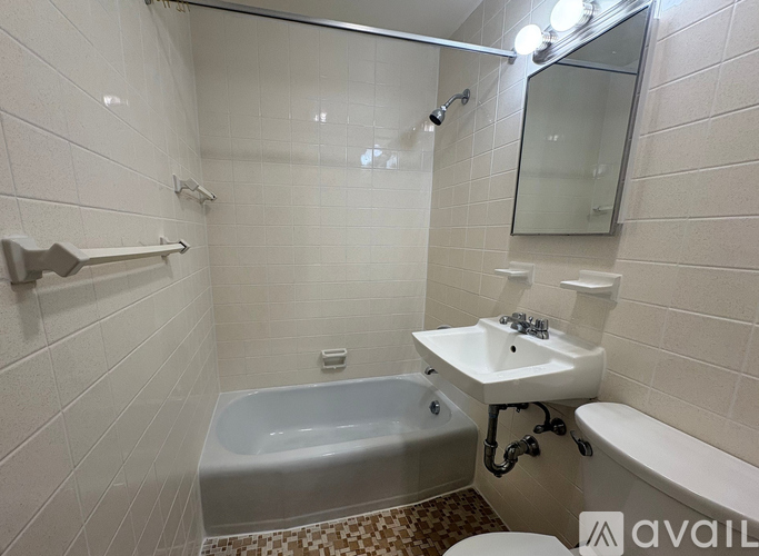 A bathroom with a white tub, sink, and toilet.
