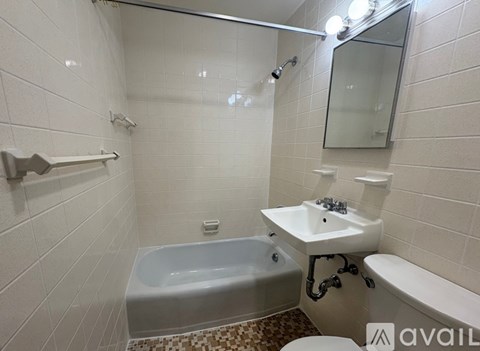 A bathroom with a white tub, sink, and toilet.