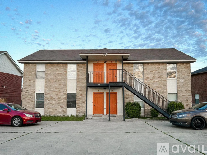 A house with a red car and a grey car parked in front.