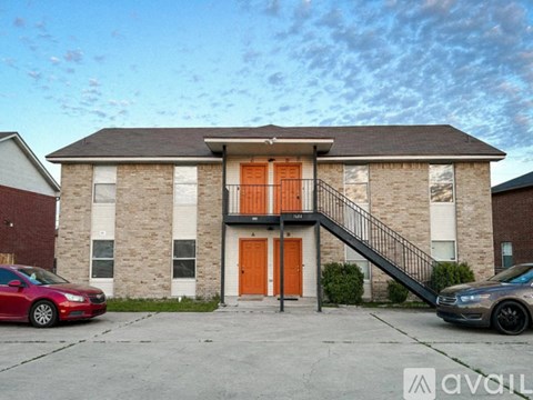 A house with a red car and a grey car parked in front.