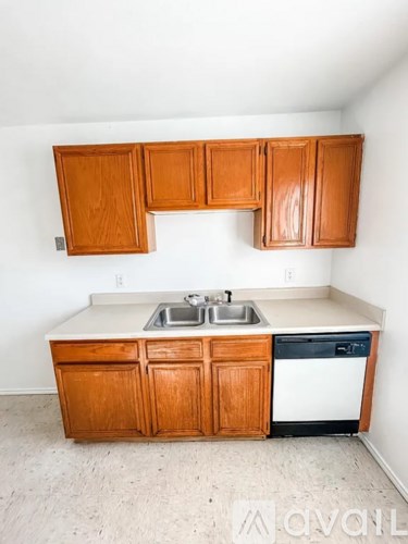 A kitchen with wooden cabinets and a white sink.