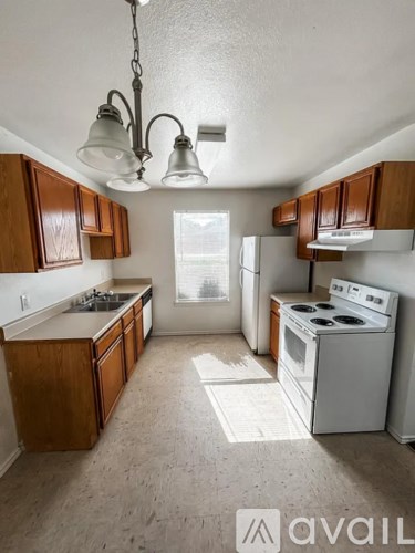 A kitchen with wooden cabinets and a white stove top oven.