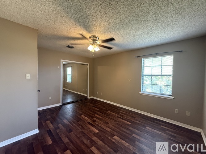 A room with wooden floors and a ceiling fan.