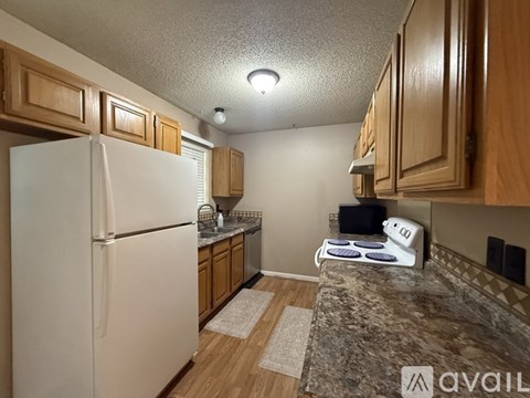A kitchen with a white refrigerator and wooden cabinets.