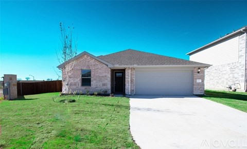 A house with a garage and a driveway in front of it.