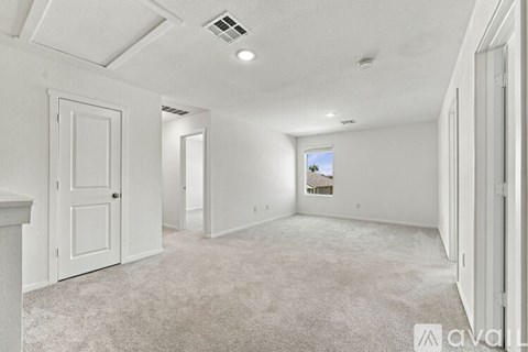 A spacious, empty room with white walls and carpeted floor.