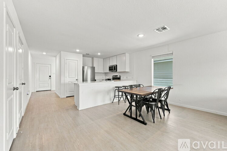 A kitchen with a table and chairs in the middle of the room.