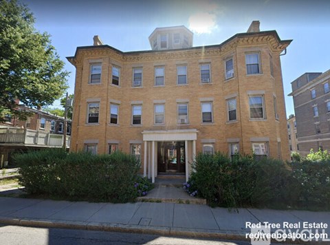 A large brick building with a white door and windows.