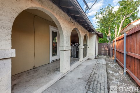 A building with arched doorways and a wooden fence.