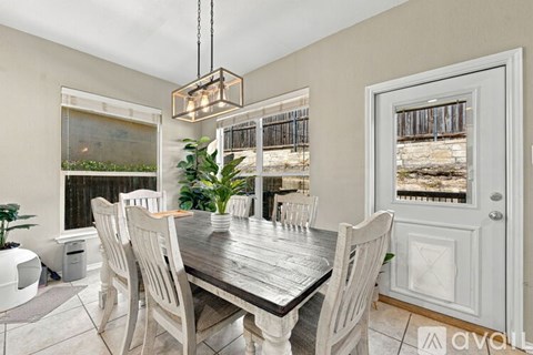 A dining room with a wooden table and chairs.