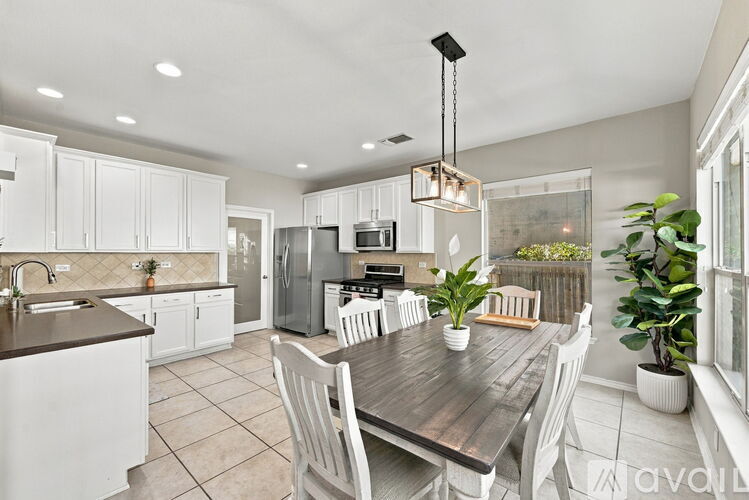 A modern kitchen with a dining table and chairs.