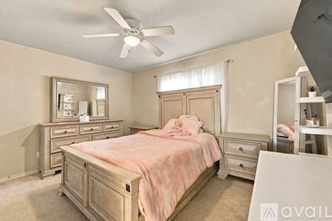 A bedroom with a bed, dresser, and mirror.