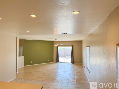 A spacious room with a green wall and a sliding glass door.