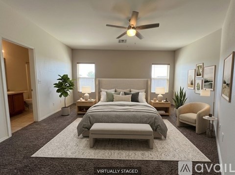A bedroom with a bed, a chair, and a ceiling fan.