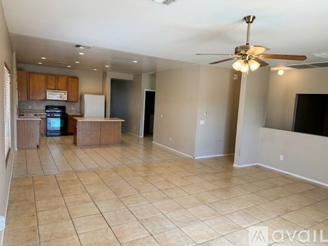 A spacious living room with a kitchen in the background.