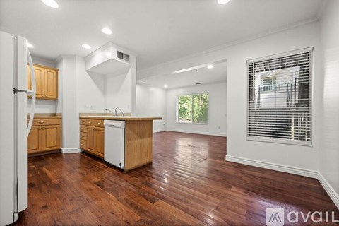 A kitchen with wooden floors and white appliances.
