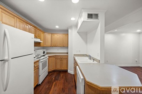 A kitchen with white appliances and wooden cabinets.