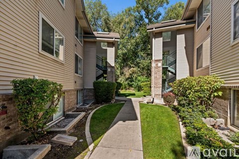 A residential building with a green lawn in front.