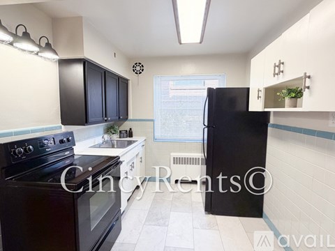 A kitchen with black cabinets and a black refrigerator.